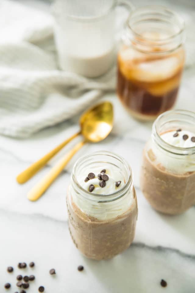photo of Cold Brew Coffee Overnight Protein Oats in a jar with two gold spoons and cold brew coffee in a jar