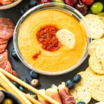 cracker dipped in Sabra Roasted Red Pepper Hummus