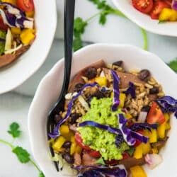 overhead view of Healthy Sweet Potato Burrito Bowls in white bowls with a black fork