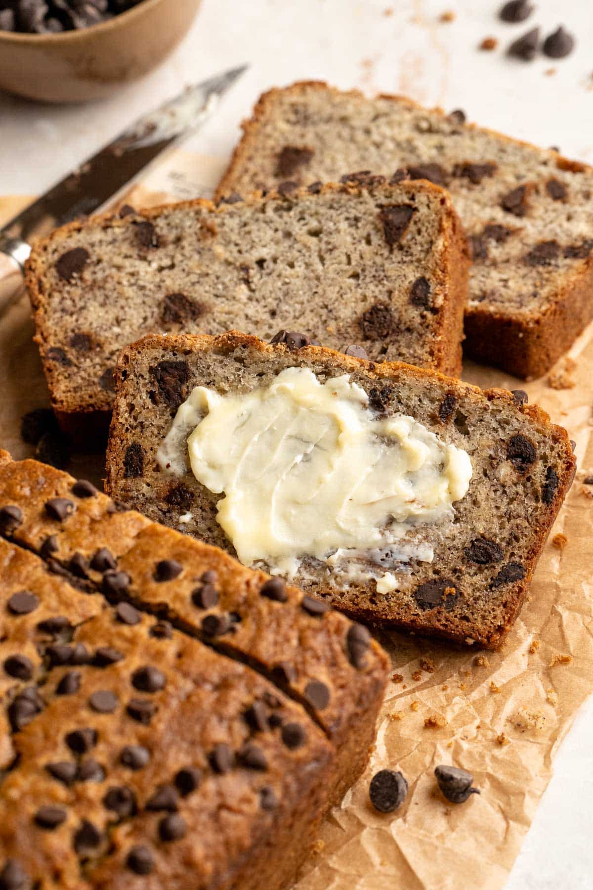 Banana oat bread sliced and one piece with butter.