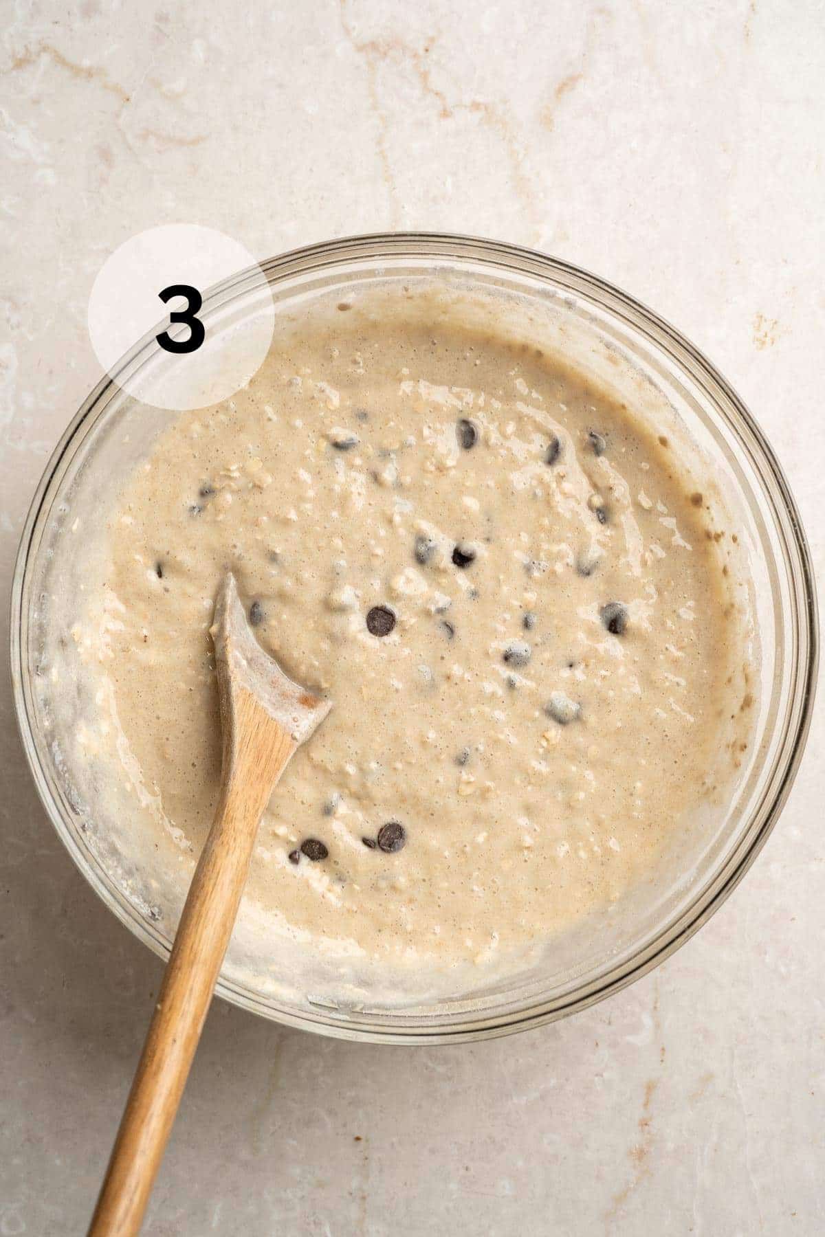 Stirring chocolate chips into banana bread batter.