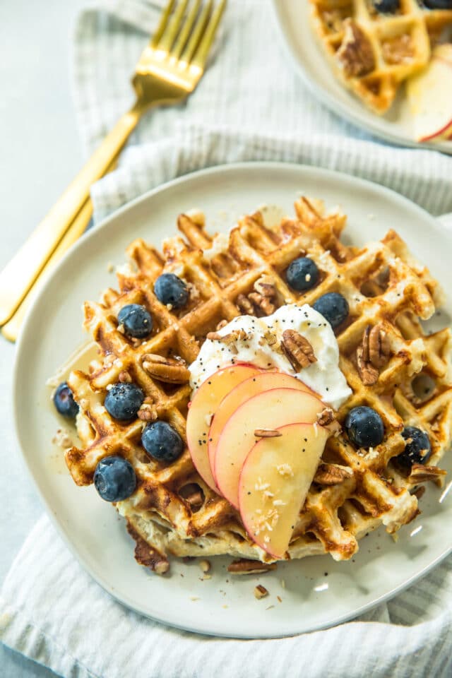 healthy protein waffle recipe topped with sliced apples, Greek yogurt and blueberries