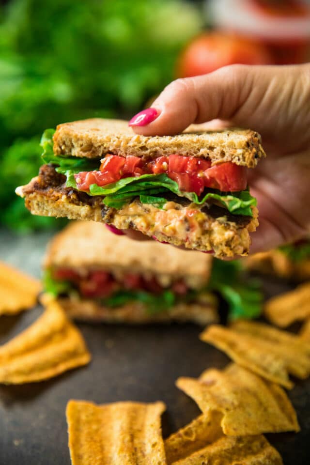 woman's hand holding a 5-Ingredient pimiento cheese BLT sandwiches