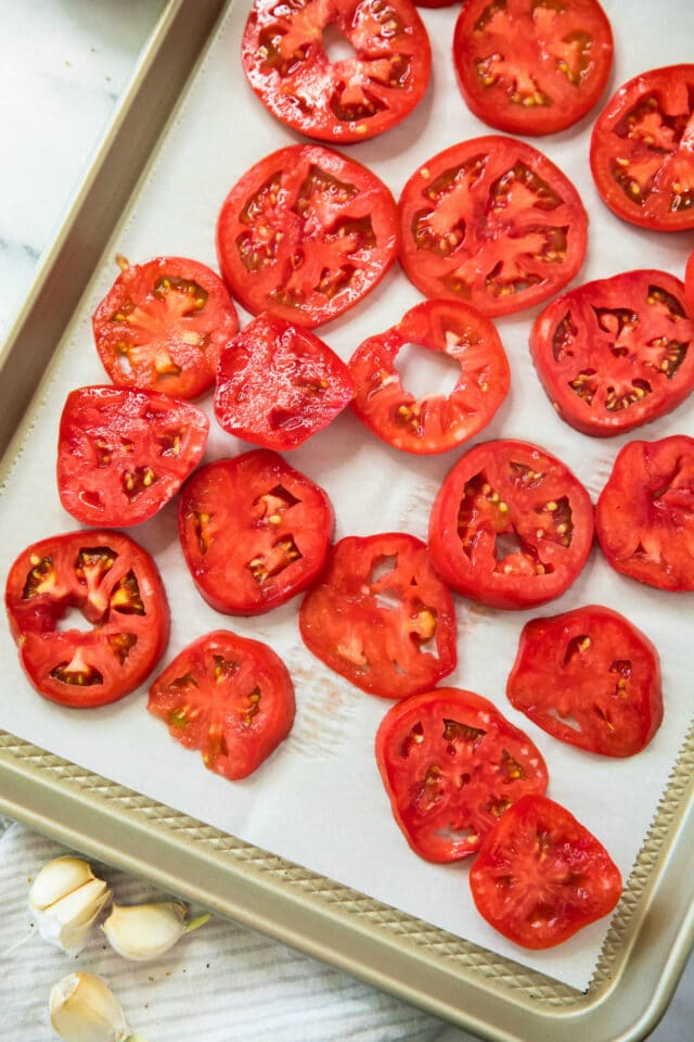 overhead view of sliced tomatoes on a baking sheet