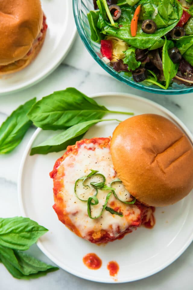 Healthy Chicken Parmesan Burgers on a white plate with top bun off