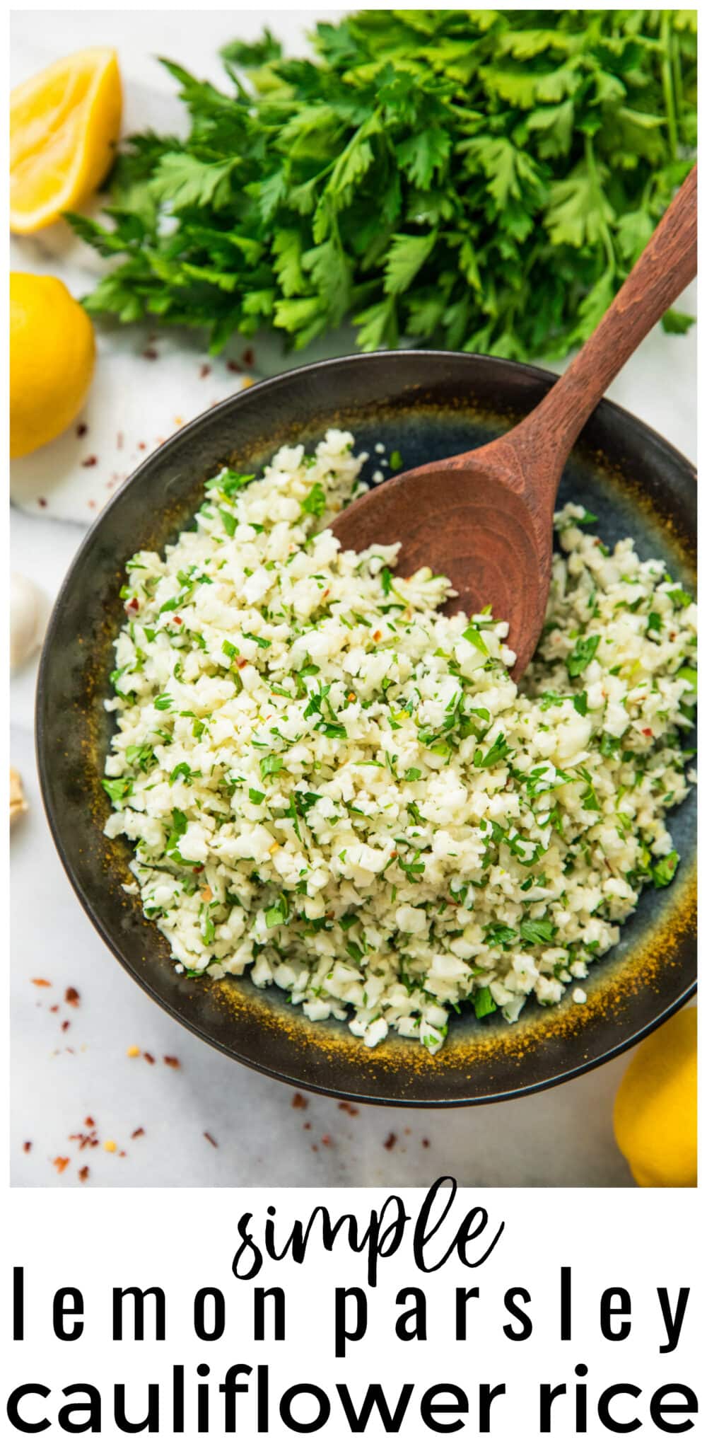 Simple Lemon Parsley Cauliflower Rice in a black bowl with wooden serving spoon