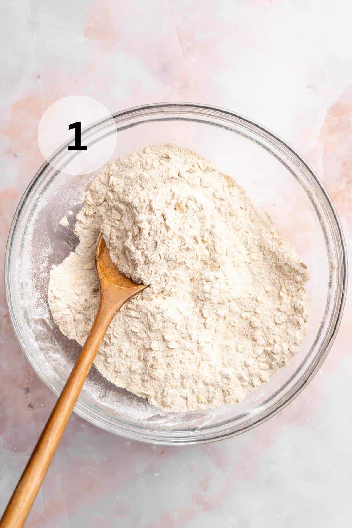 Stirring flour with oats, sugar and cinnamon.