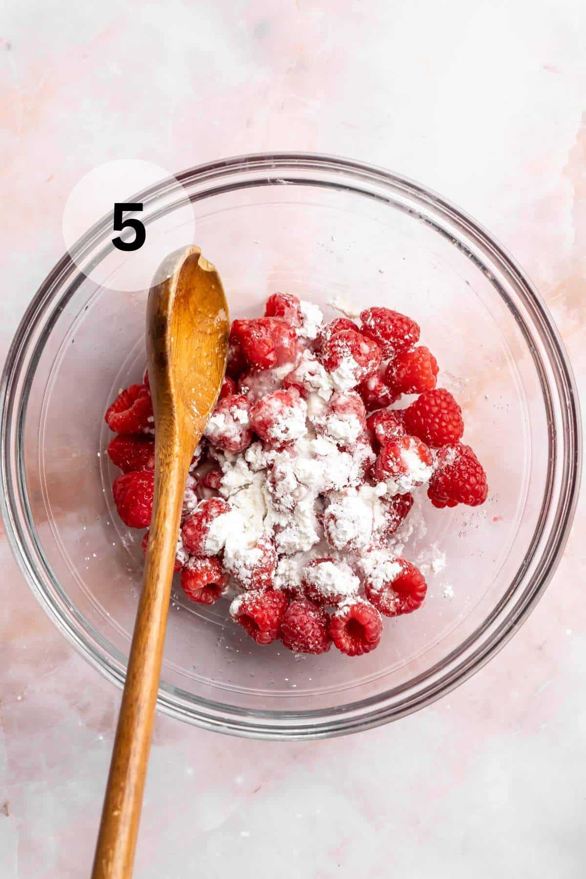 Mixing cornstarch with lemon juice and fresh raspberries.