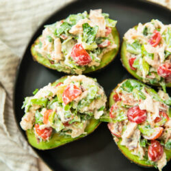 overhead view of BLT Chicken Salad Stuffed Avocados on a black plate