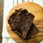 overhead view of stacked slices of Healthy Double Chocolate Zucchini Bread on a round wooden board