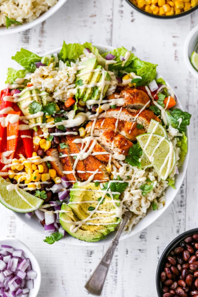 burrito bowls topped with chicken, avocado and dressing