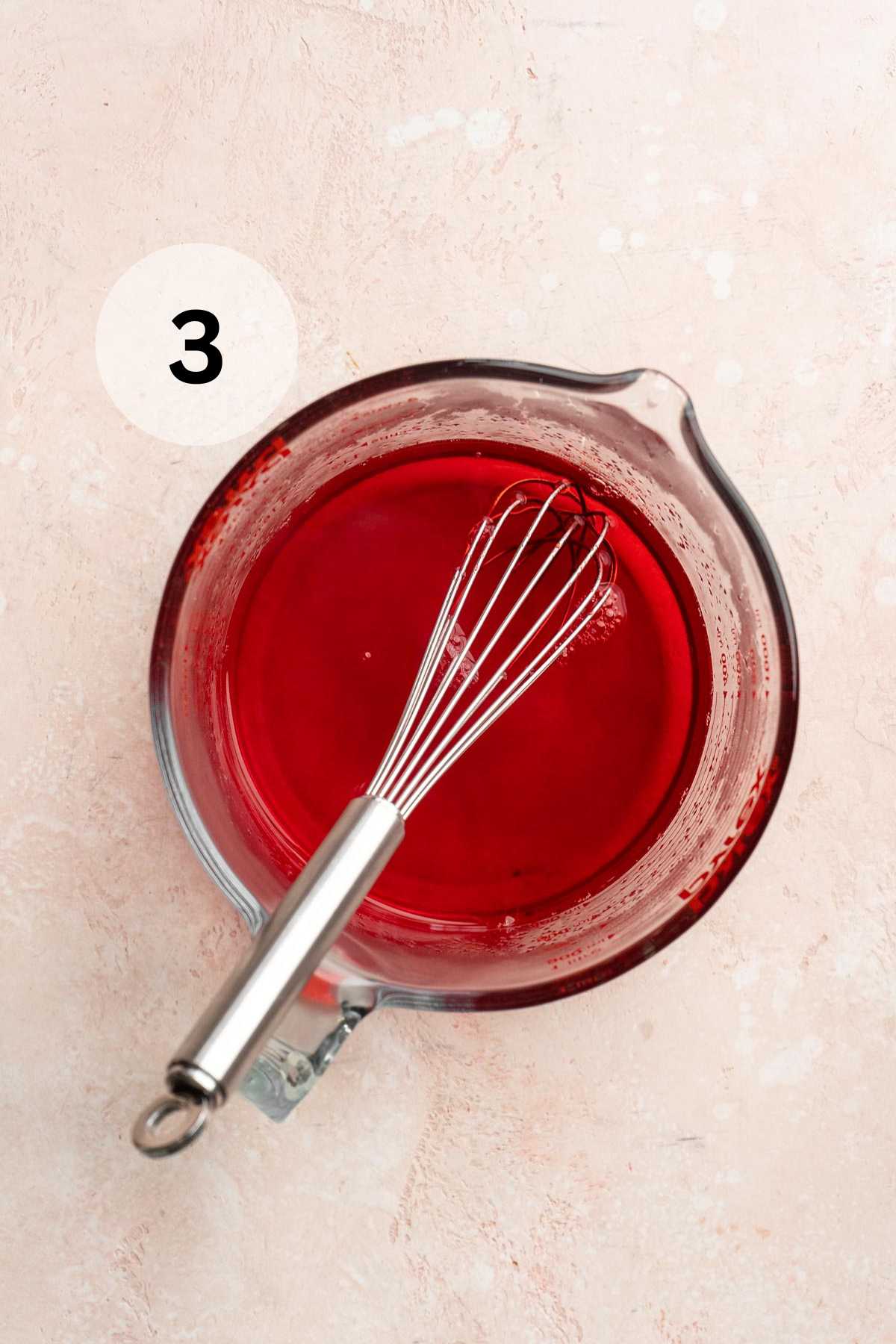 Whisking gelatin with boiling water.