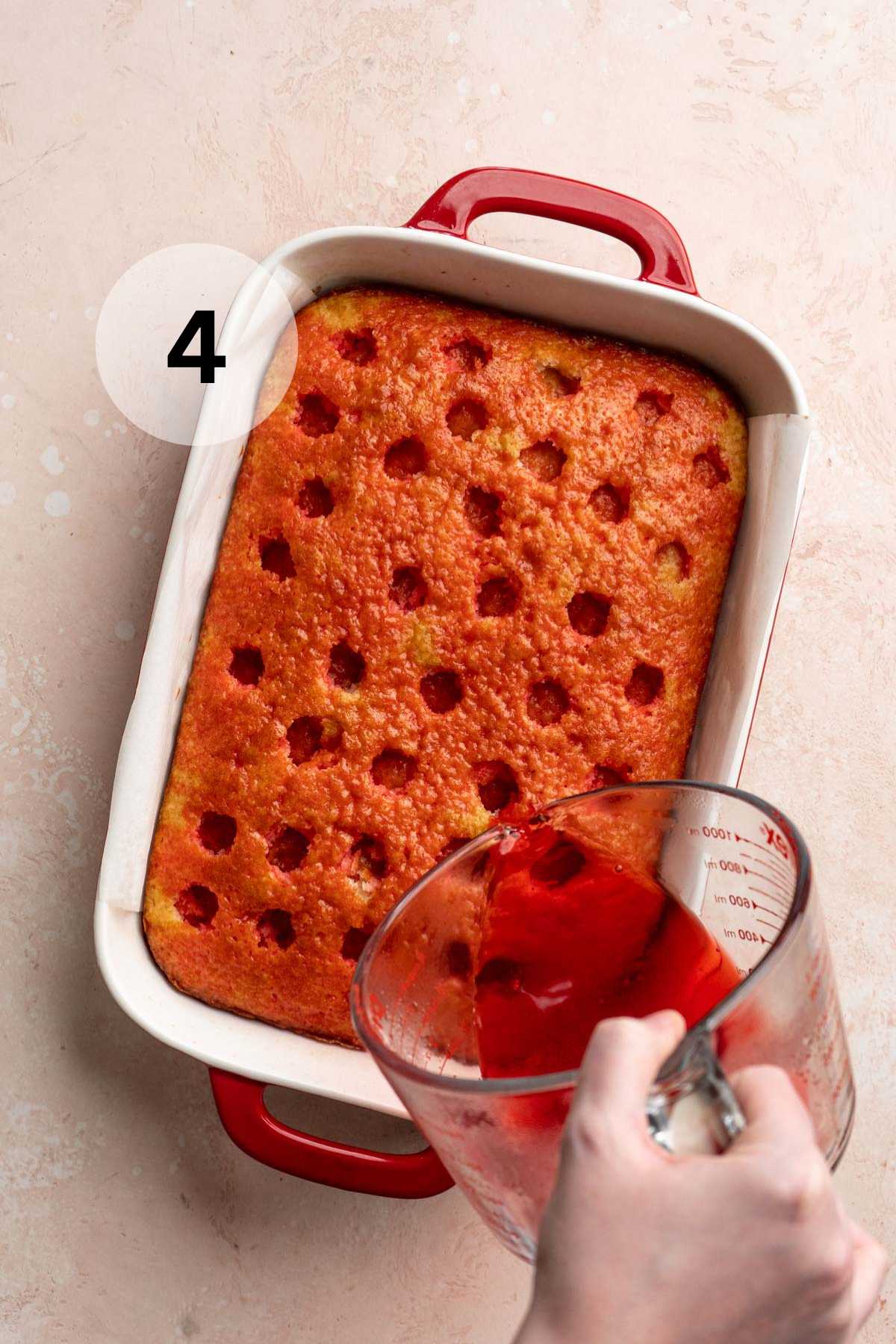 Pouring gelatin over the top of a cake that has holes.