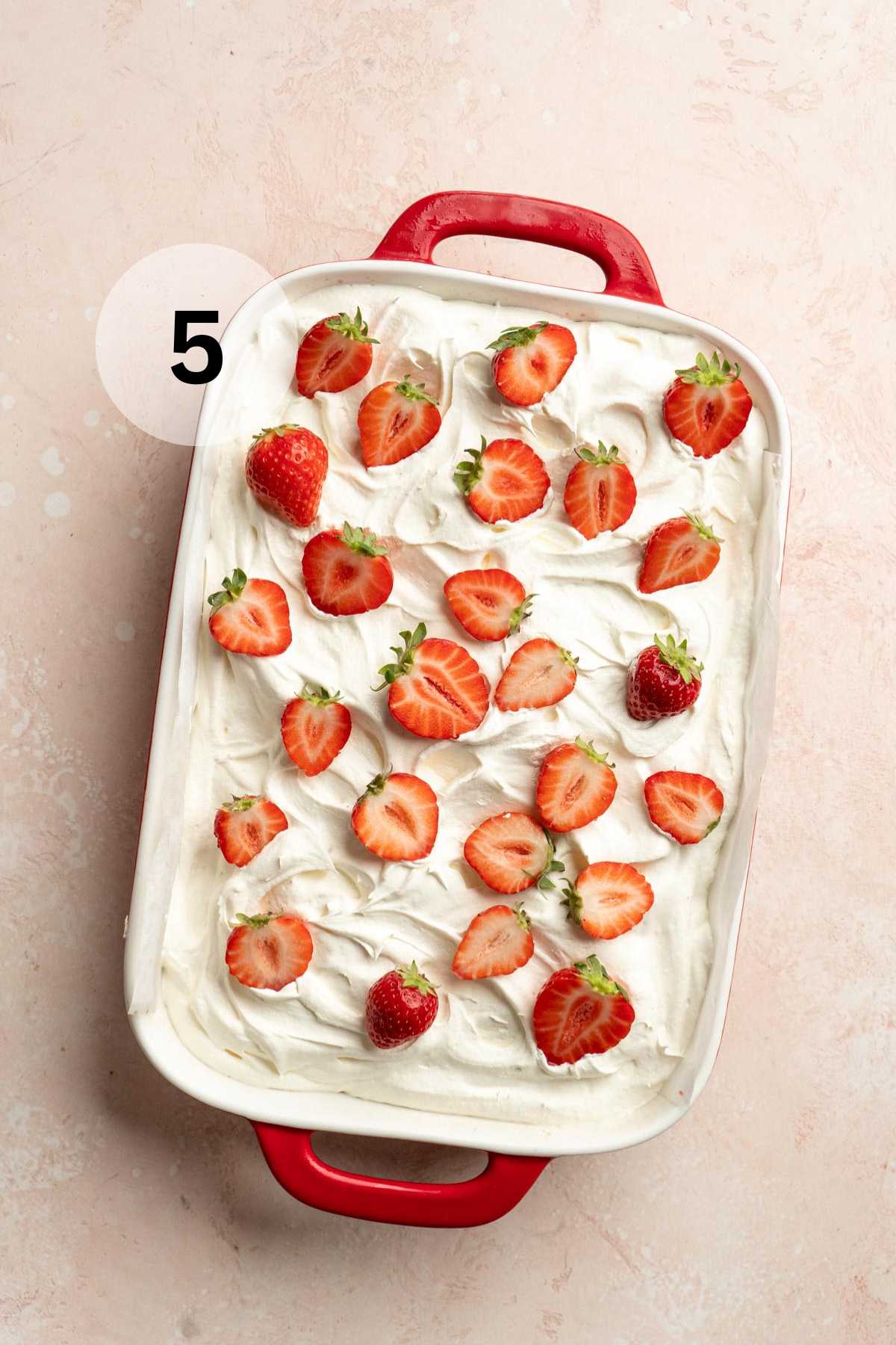Cake decorated with whipped topping and fresh strawberries.