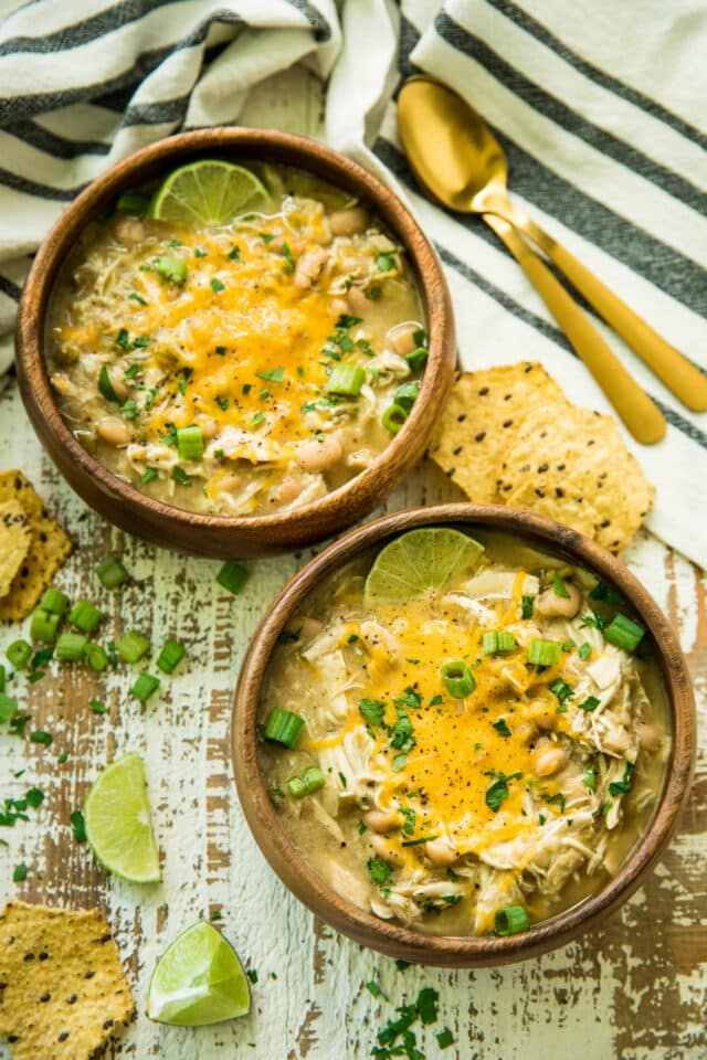 overhead view of two wooden bowls of Gut-Healing Easy Slow Cooker White Chicken Chili
