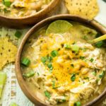 overhead image of Gut-Healing Easy Slow Cooker White Chicken Chili served in a wooden bowl with a gold spoon