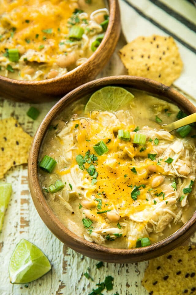 overhead image of Gut-Healing Easy Slow Cooker White Chicken Chili served in a wooden bowl with a gold spoon