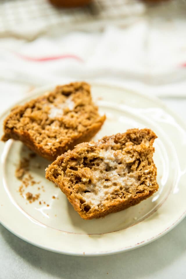 Healthy Apple Spice Crumb Muffins sliced on a plate with a spread of butter