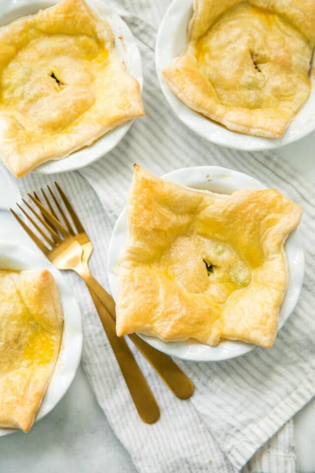 overhead photo of Rotisserie Chicken Pot Pie in a mini white pie plate with gold forks on the side