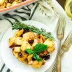 Easy Bacon Apple Stuffing Recipe on a white plate with two silver forks