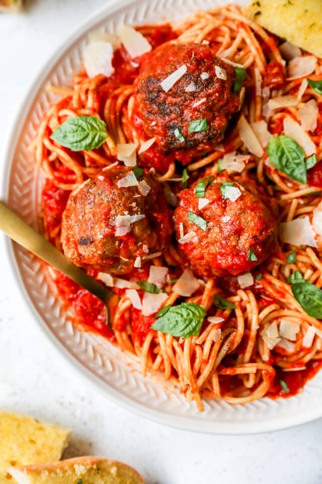 spaghetti and meatballs served with a gold fork 
