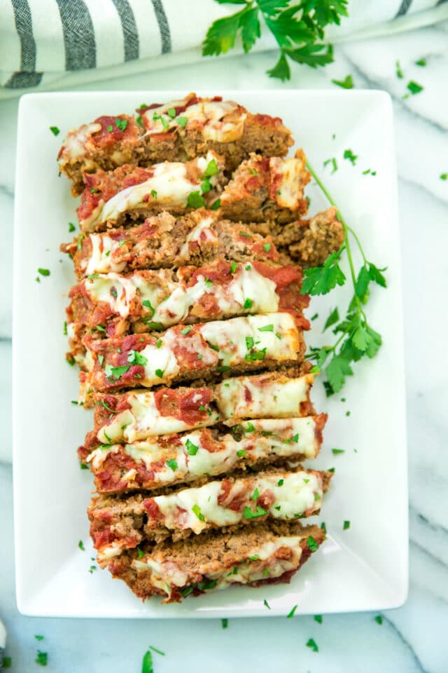 overhead image of Cheesy Italian Meatloaf Recipe sliced on a white serving platter