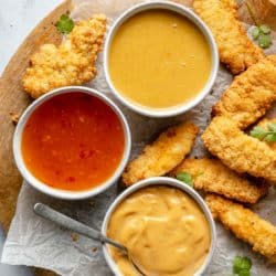 Bowls of dipping sauce served with chicken tenders.