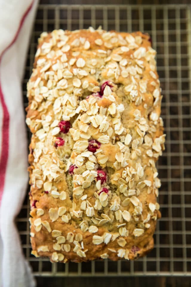 loaf of cranberry pecan banana bread on a cooling rack