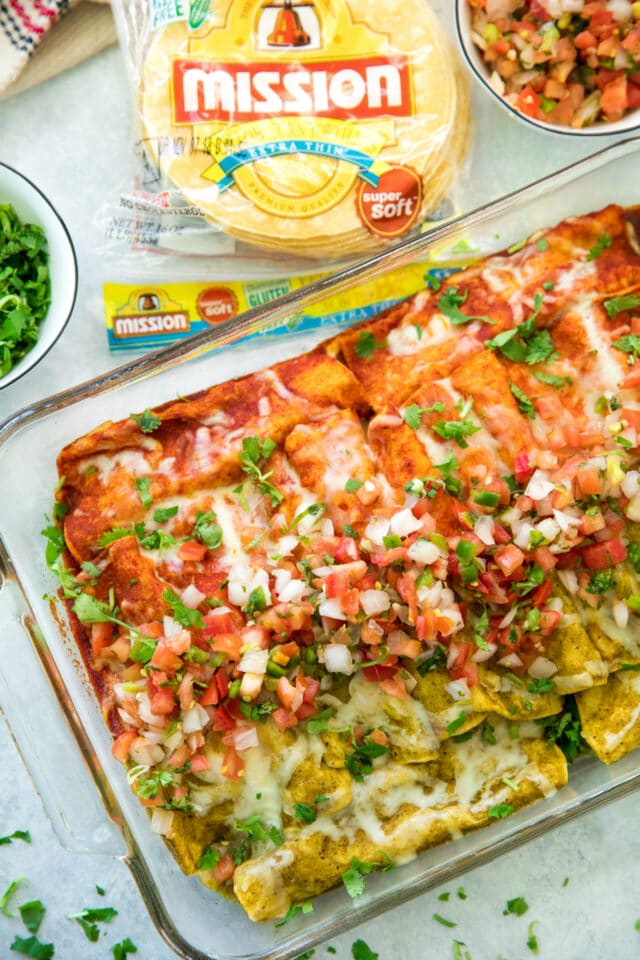 enchiladas made with red and green sauce in a baking dish