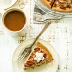 healthy pecan pie topped with whipped cream on a plate with a fork
