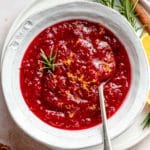 Fresh cranberry sauce in a white bowl with a spoon.
