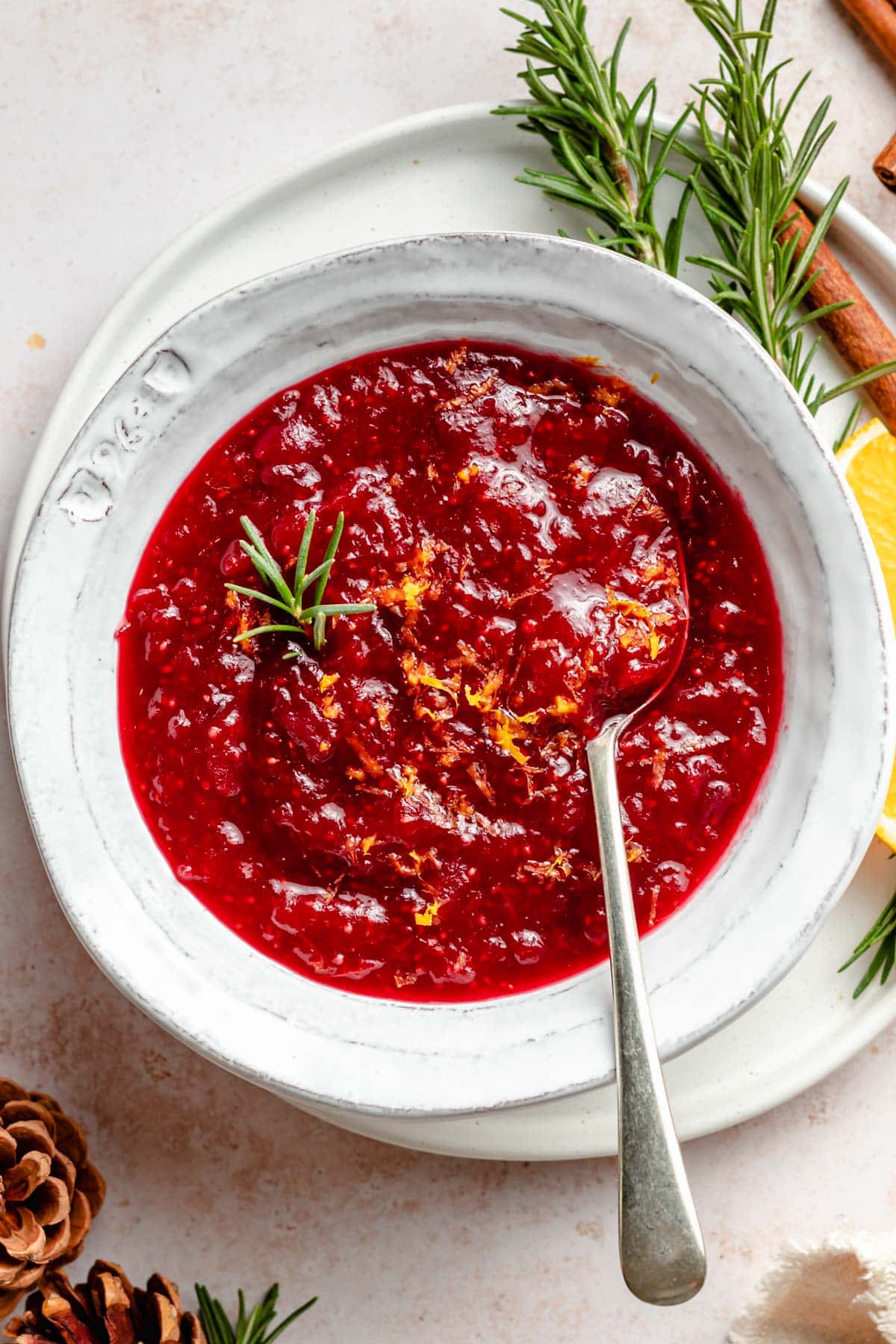 Fresh cranberry sauce in a white bowl with a spoon.