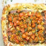 cooked puff pastry tomato tart topped with fresh thyme