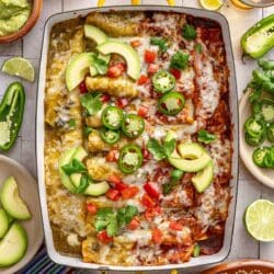 Chicken enchilada recipe in a glass baking dish topped with sliced jalapeños and avocado slices.
