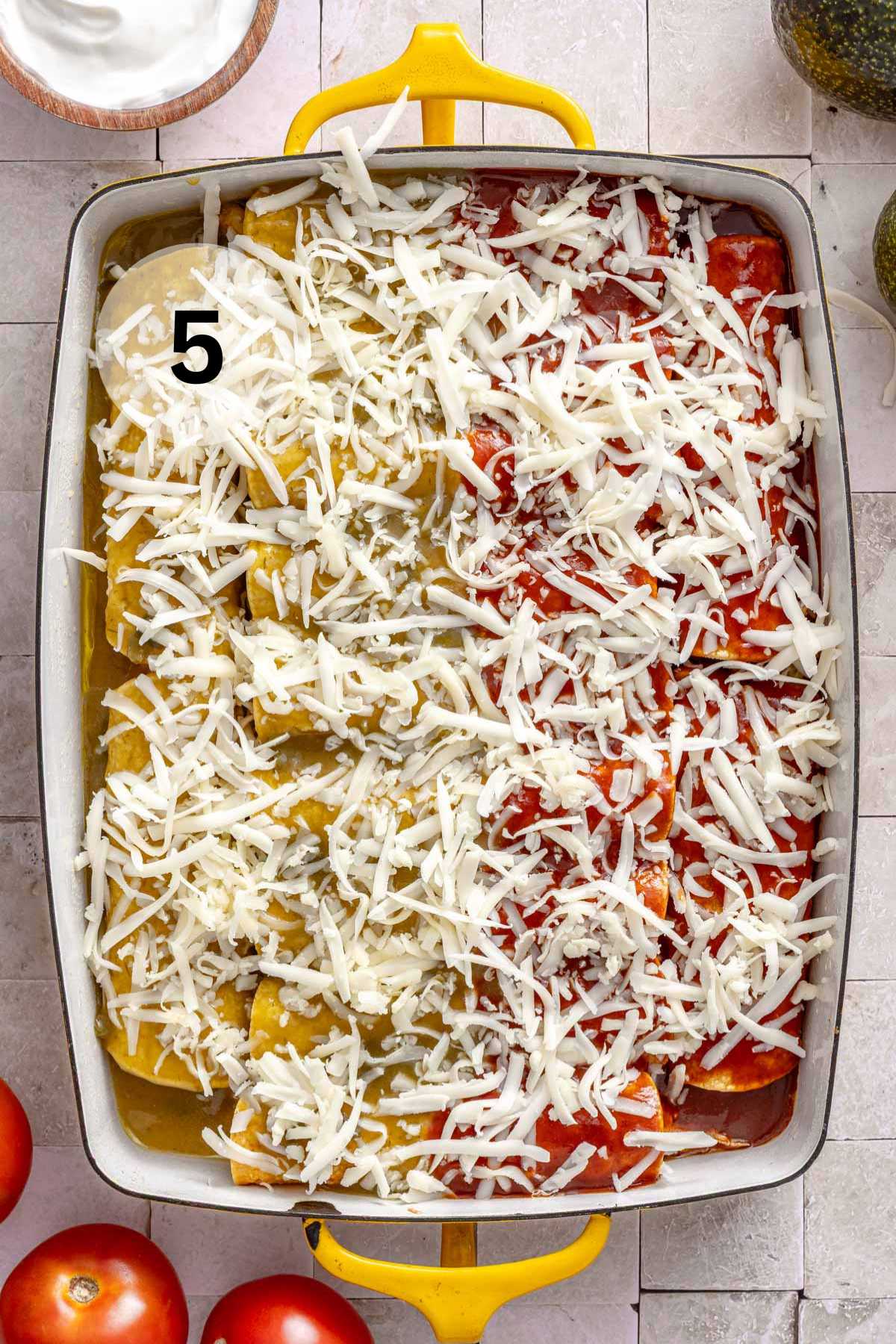 Unbaked enchiladas sprinkled with cheese.