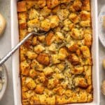 Turkey dressing in a white casserole dish with a serving spoon.