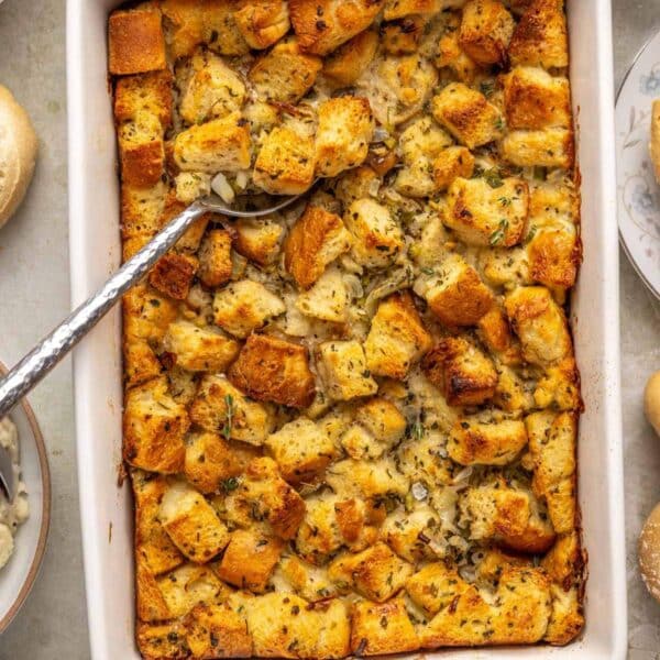 Turkey dressing in a white casserole dish with a serving spoon.