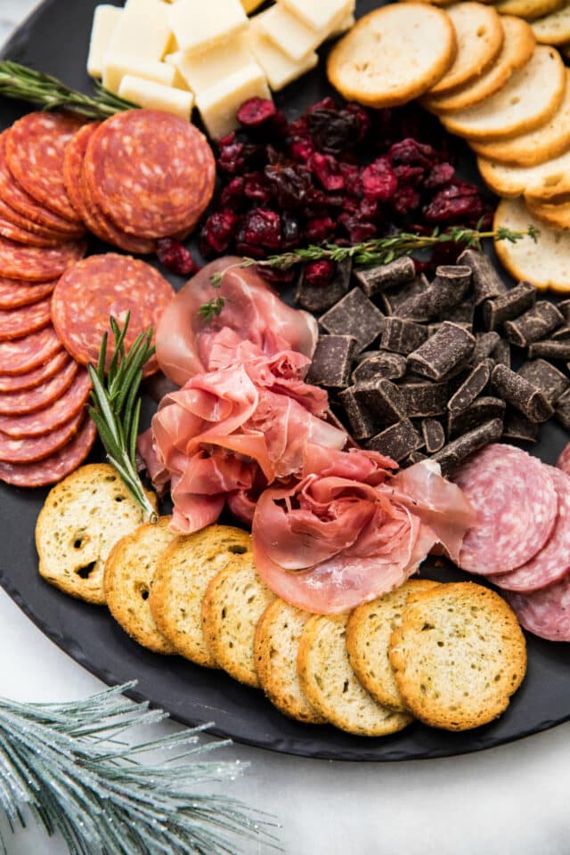 cheese and meat board on a black serving tray