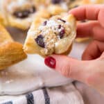 woman's hand holding a grape almond puff pastry bite