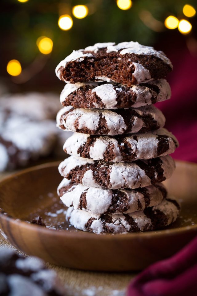 chocolate cookies stacked in front of a Christmas tree