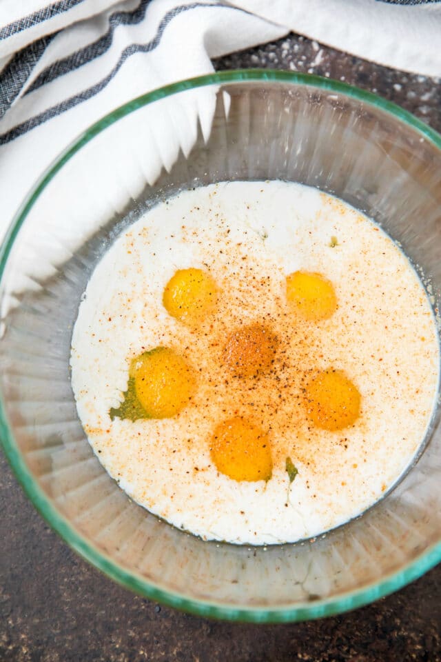 egg and milk mixture in a glass bowl with seasoning