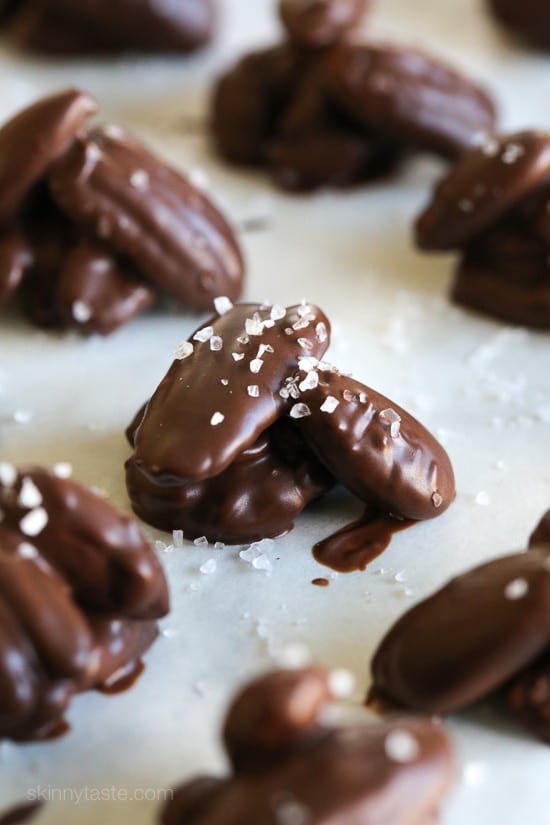 chocolate nut clusters topped with sea salt on parchment paper