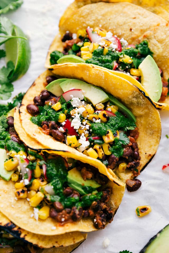 vegetarian tacos topped with avocado slices and corn