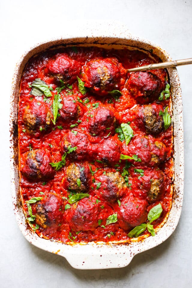 Epic Whole30 Baked Meatballs in a large baking dish covered with marinara sauce 