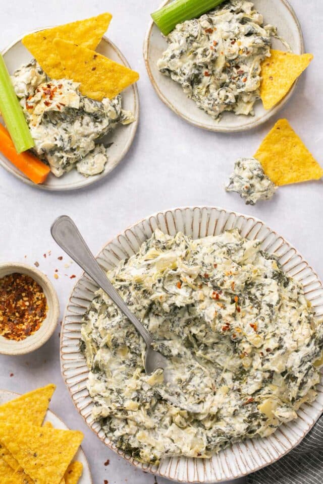 Spinach artichoke dip that has been eaten out of a plate.