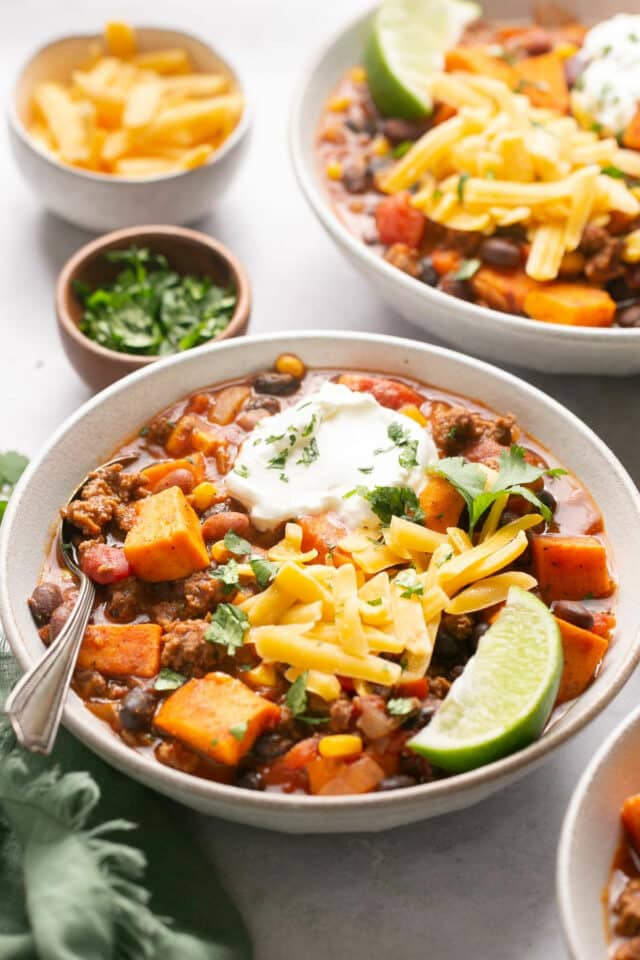 Chili in a white bowl with cubed sweet potato and beef.
