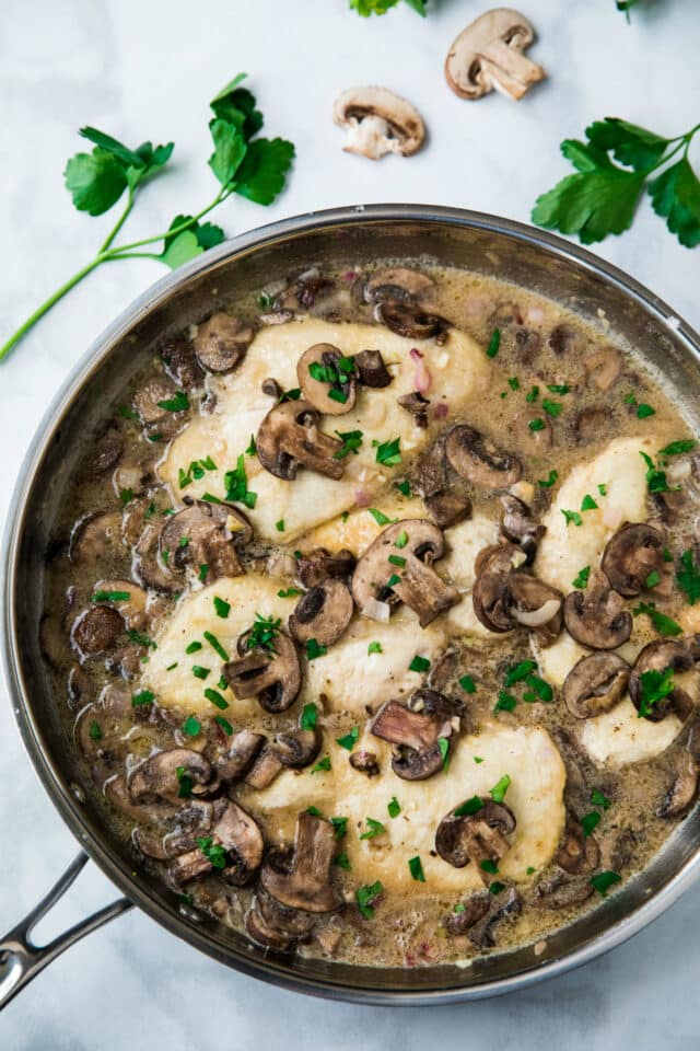 Chicken cooking in a mushroom sauce in a large skillet