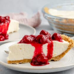 slice of cream cheese pie topped with cherries