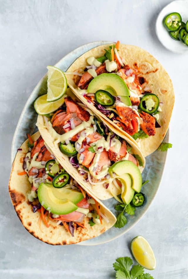 3 seared salmon tacos on a plate 
