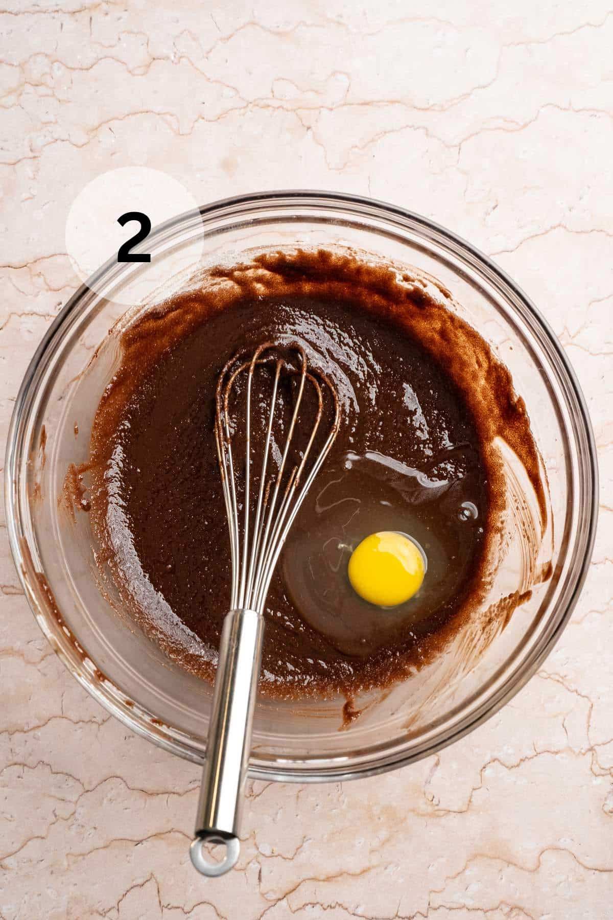 Mixing egg into brownie batter.